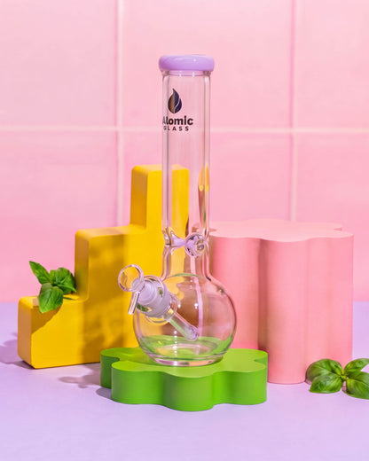 Clear 12-inch Atomic Glass bong with a rounded bubble base, lavender mouthpiece rim, downstem, and removable 14mm glass bowl.