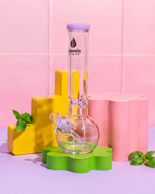 Clear 12-inch Atomic Glass bong with a rounded bubble base, lavender mouthpiece rim, downstem, and removable 14mm glass bowl.