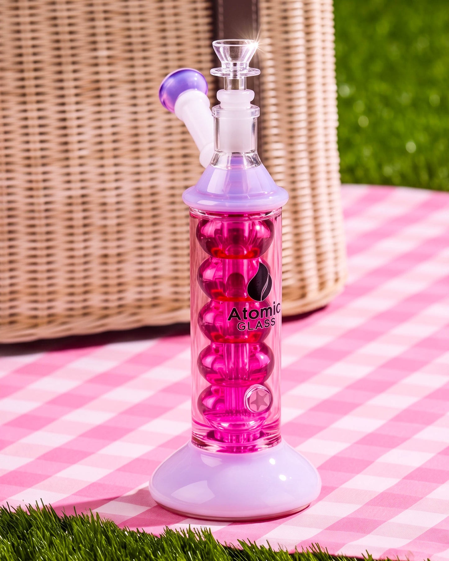 Pink and lavender 10.5-inch Atomic Glass glycerin bong with bubble-style cooling chamber, flared base, angled mouthpiece, and clear 14mm bowl.