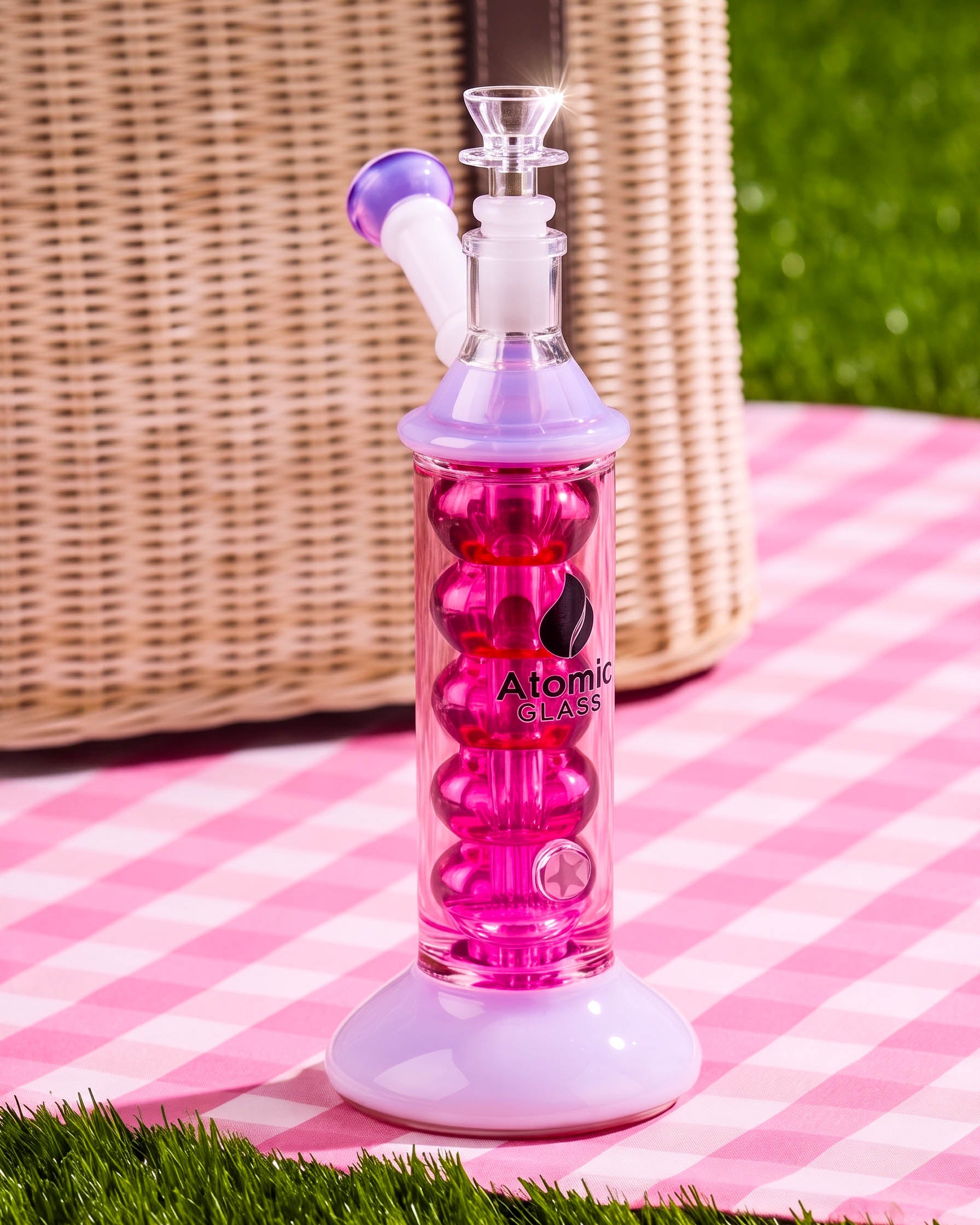 Pink and lavender 10.5-inch Atomic Glass glycerin bong with bubble-style cooling chamber, flared base, angled mouthpiece, and clear 14mm bowl.
