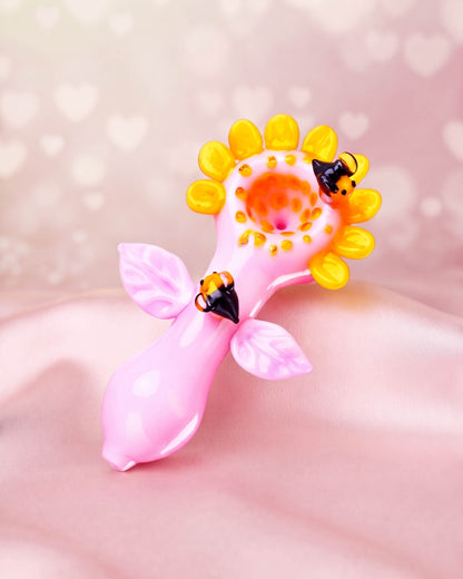 Pink 5-inch flower glass hand pipe with yellow sunflower petals, pink leaves, and sculpted bumblebee details.