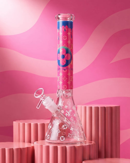 Clear 12-inch beaker bong with pink and blue designer-inspired monogram graphics, floral emblem, angled downstem, and removable 14mm glass bowl.