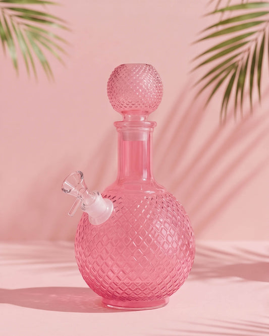 Pink 9.75-inch decanter-style glass bong with diamond-cut texture, round matching stopper, rounded chamber, and removable 14mm glass bowl.