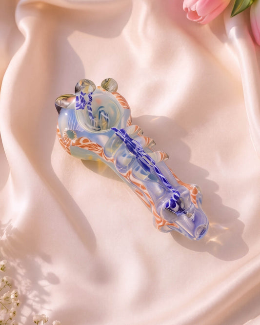 5-inch fumed glass hand pipe with blue and orange marbled swirl details, sculpted glass accents, built-in bowl, and side carb.