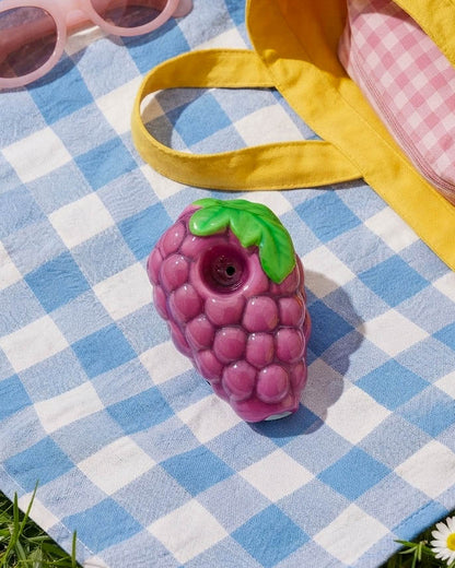 Purple grape-shaped 3.5-inch ceramic hand pipe with raised berry texture, green leaf detailing, and built-in bowl.