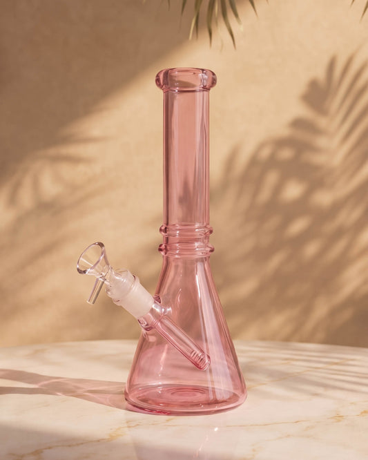 Blush pink 10-inch beaker bong with a clear downstem, wide stable base, straight neck, and removable 14mm glass bowl.