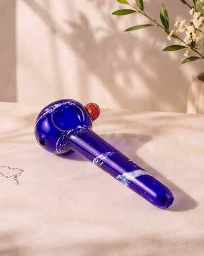 Cobalt blue 5-inch fumed glass hand pipe with white stardust-style accents, rounded bowl, side carb, and smooth mouthpiece.